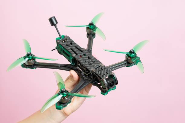 istock Hand holding modern drone with camera isolated on pink background 2193725246