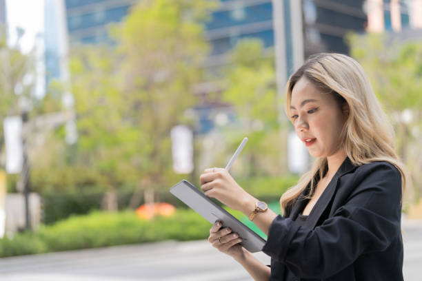 istock Confident businesswoman holding a tablet and stylus, emphasizing precision and adaptability in a contemporary workspace, blending style and functionality. 2193726095