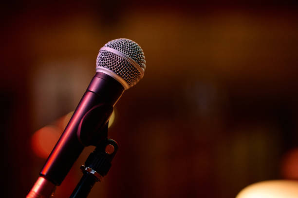 istock Microphone ready for a heavy metal concert with energetic crowd in background 2193731631