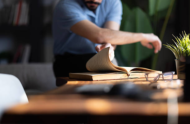 Young man reading book in the library