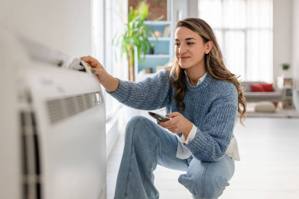 istock Woman interacts with air conditioner in living space. 2193738305