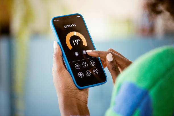 istock Woman using mobile phone to control termostat at home 2193738504