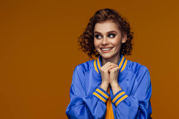 istock Excited Young Woman in Blue Jacket with Hands Clasped 2193739026