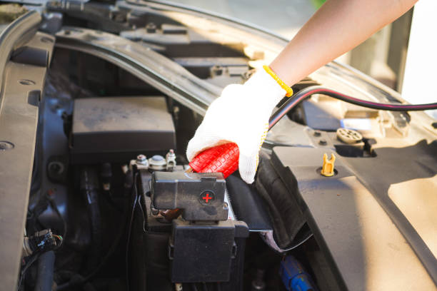 istock Action of a technician hand is using an emergency clamping kit to clamp on positive polar for jumping the 12V car battery. 2193740473