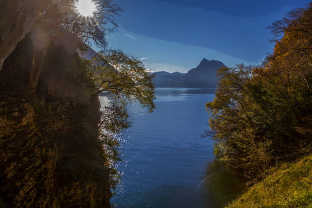 Awe view on lake Lugano   from pedestrian Olive trail in Lugano city suburb. Autumn leaf color and sunny day in southern Switserland  (canton Ticino). Mount San Sebastiano in distance