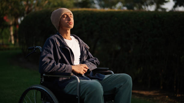 istock Man sitting on wheelchair at park. 2193745879