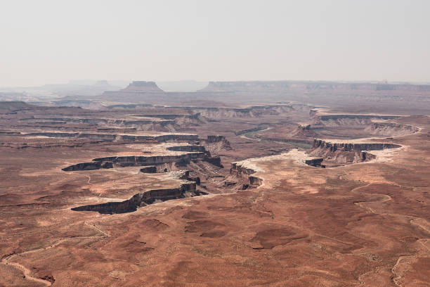 A sweeping panoramic view of Canyonlands National Park, capturing its vast and rugged terrain. The scene features dramatic canyons, towering mesas, and intricate rock formations that stretch across the horizon. With its breathtaking vistas and striking geological features, the park showcases the unparalleled beauty of the American Southwest, inviting visitors to immerse themselves in nature’s grandeur.