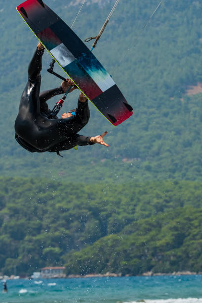 istock A kitesurfer in mid-air trying to grab his kiteboard. 2193748240