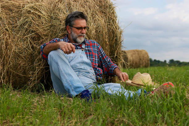 istock Senior modern farmer relaxing on field of grass 2193749480