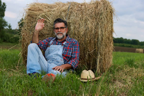 istock Senior modern farmer relaxing on field of grass 2193749513