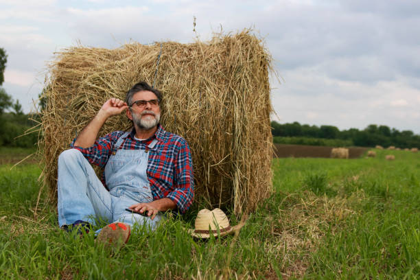 istock Senior modern farmer relaxing on field of grass 2193749546