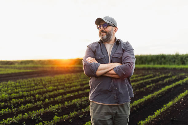 istock Confident Farmer Standing in a Sunlit Green Field During Sunset 2193755322