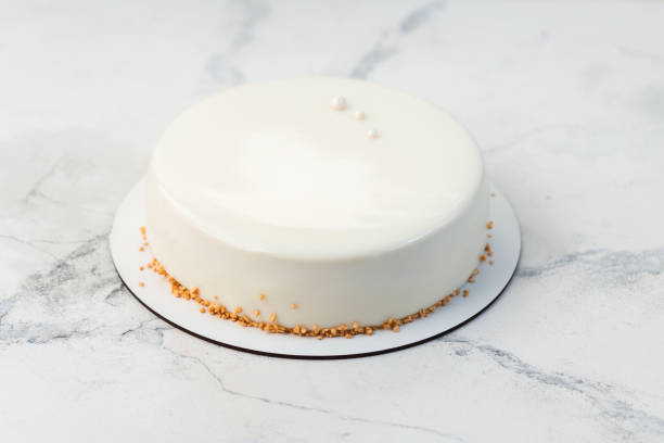 istock Simple white mousse cake decorated with dried waffle crumbs and covered with smooth chocolate glaze. White marble background 2193761888