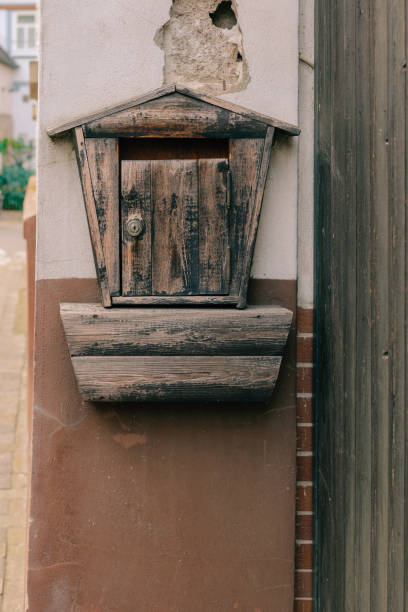 istock Old wooden mailbox mounted on a weathered wall with rustic charm 2193763465