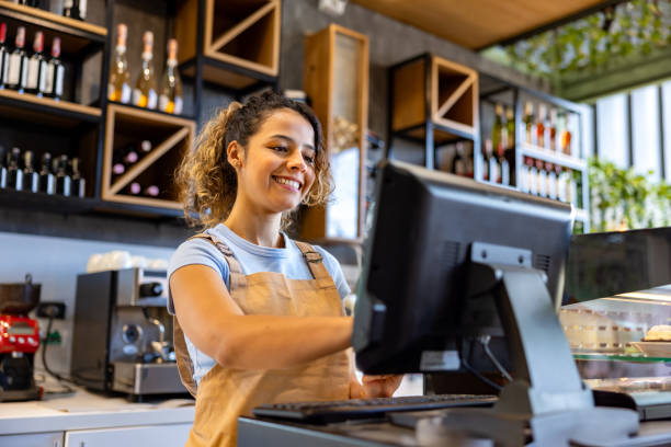 istock Happy waitress working at a cafe and using the cash register 2193767318
