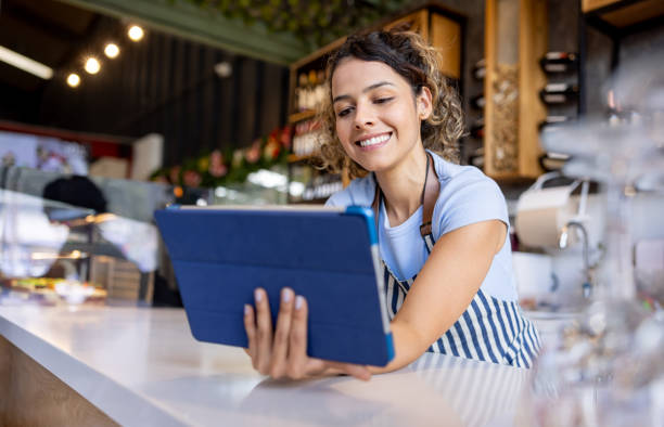 istock Barista working at a cafe using a digital tablet and smiling 2193767350