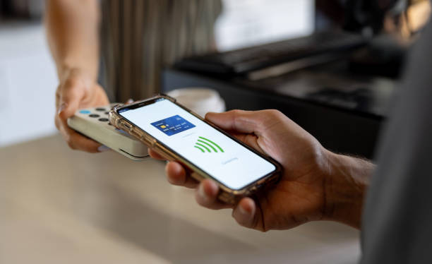 istock Close-up on a customer making a mobile payment at a coffee shop 2193767359