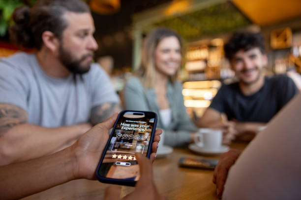 Close-up on a customer rating his experience at a restaurant using his cell phone