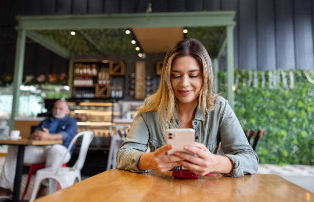 istock Woman at a cafe using her cell phone 2193767415