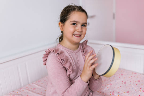 Girl playing percussion instrument at home.