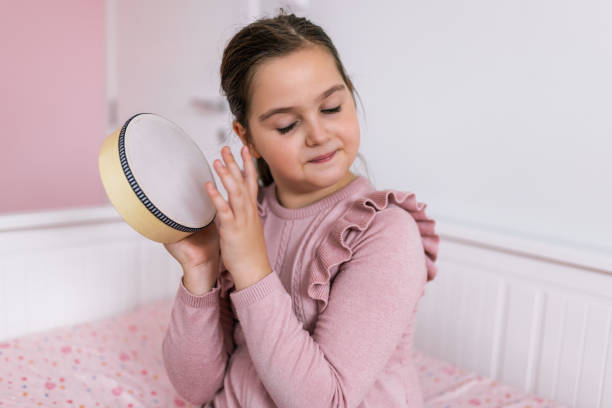 istock Girl playing percussion instrument at home. 2193768521