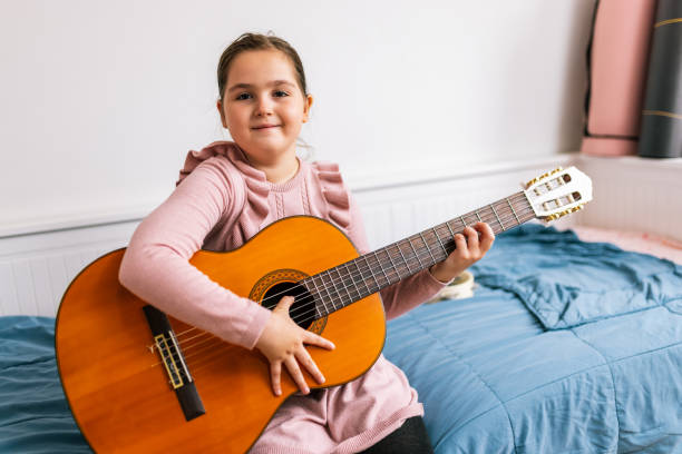 istock Little girl playing guitar in her room. 2193768633