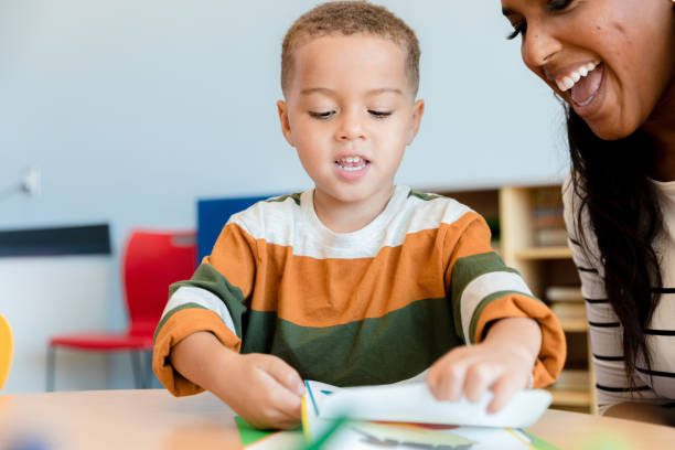 istock Teacher and Preschool Student Reading Together in Classroom 2193770044