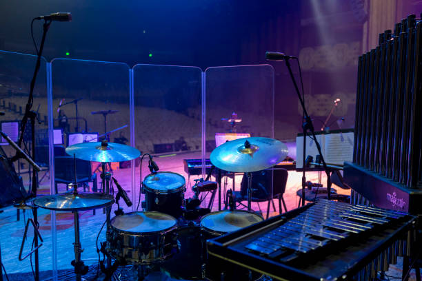 istock Drum kit, bells and metallophone with microphone support behind a transparent noise-absorbing barrier 2193771997