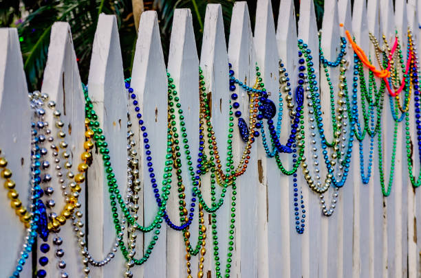 Mardi Gras beads on a golden background. Party invitation, greeting card, carnival celebration concept.