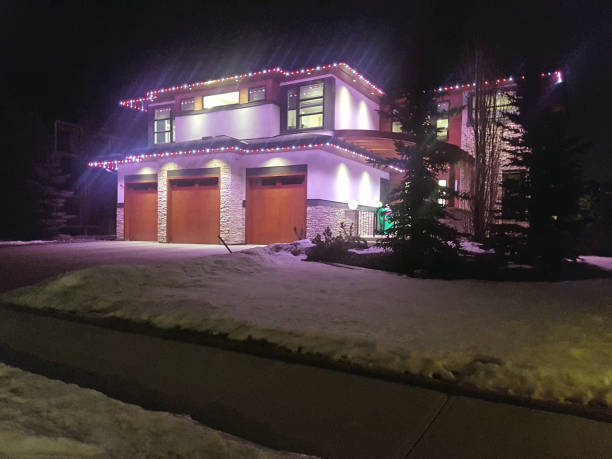 A Christmas garland in the form of houses, sparkling with lights on the tree, creates a cozy atmosphere and a magical holiday mood.