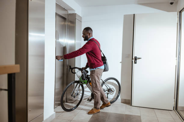 istock Male commuter with bike waiting for elevator with bicycle 2193775986
