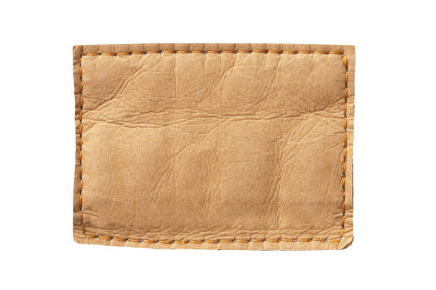 Brown leather belt strap closeup isolated on white. Brown stitched leather seam frame label tag isolated on white.
