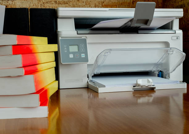 istock printer and a stack of books on his desk. Office concept 2193777569