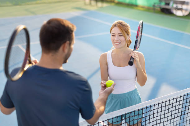 istock Friendly exchange between two tennis players at the court's net. 2193778645