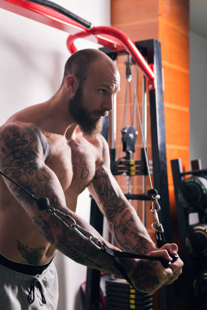 istock concentrated muscular man doing exercise at gym 2193778732