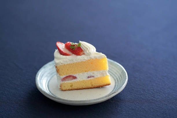 Japanese shortcake with strawberries on top is placed on a black cloth.