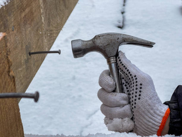 istock A man is focused, holding a hammer and driving a nail into wood 2193779480