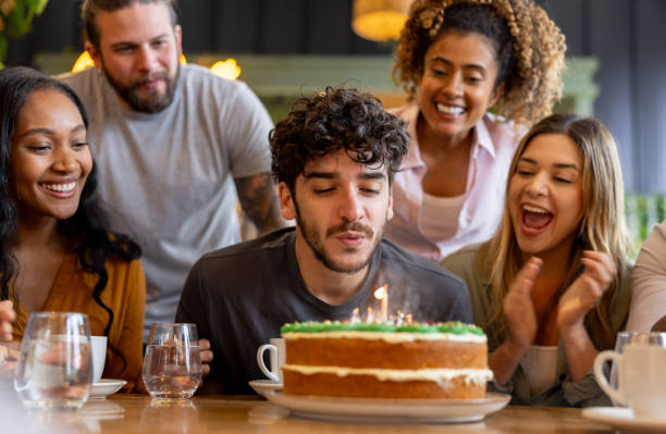 istock Birthday boy blowing the candle on his cake while celebrating 2193787965