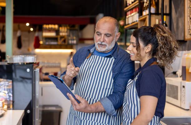 istock Manager training a new employee at a coffee shop 2193787970