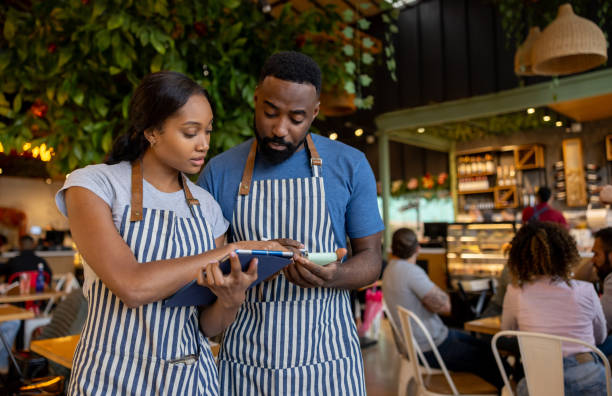 istock Waitress training a new employee at a coffee shop 2193787986