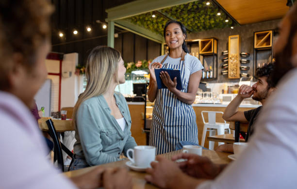 istock Waitress giving recommendations to a group of customers at a cafe 2193788020