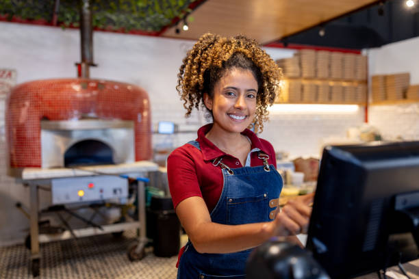 Waitress working at a pizza place using the cash register