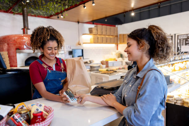 istock Woman making a contactless payment while shopping at a delicatessen 2193788046