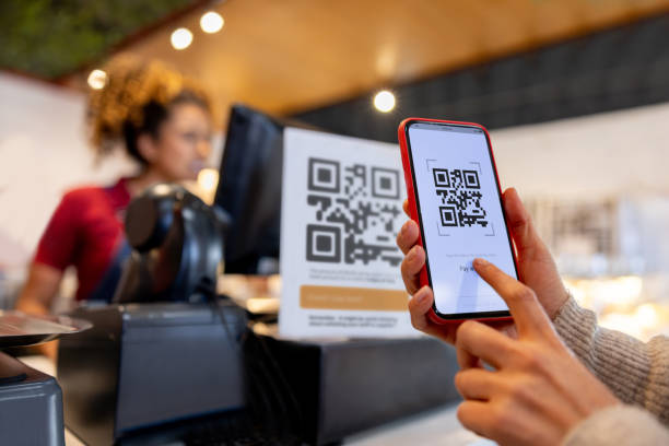 istock Close-up on a woman making a mobile payment scanning a QR code 2193788051