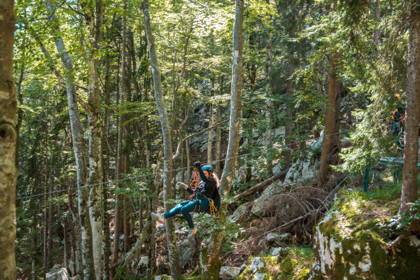 istock Young Female Thrill-seeker Gliding Through The Lush Forest Canopy 2193790244