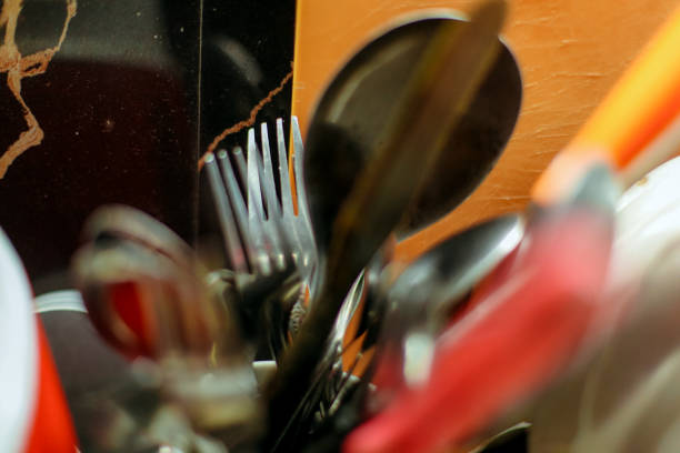 Focus on the fork among the spoons and other cutlery