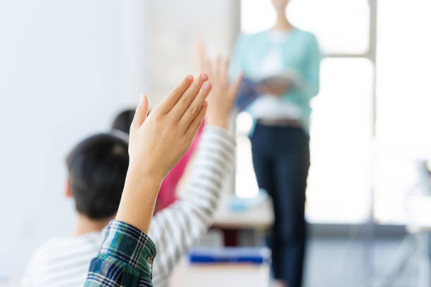 istock Class image of elementary school students raising their hands in the classroom 2193796029
