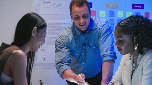 istock Diverse Collaborative Business people meeting with Digital Devices computer brainstorming the financial report paperwork document analyzing data or planning strategies displays a graph or chart in a modern business technology  at night 2193800388