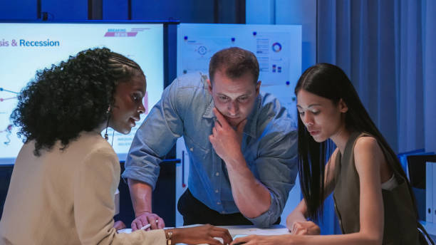 istock Diverse Collaborative Business people meeting with Digital Devices computer brainstorming the financial report paperwork document analyzing data or planning strategies displays a graph or chart in a modern business technology  at night 2193800428
