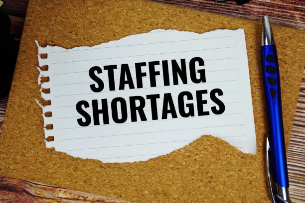 istock Staffing Shortages text written on paper torn top view on wooden background 2193808464
